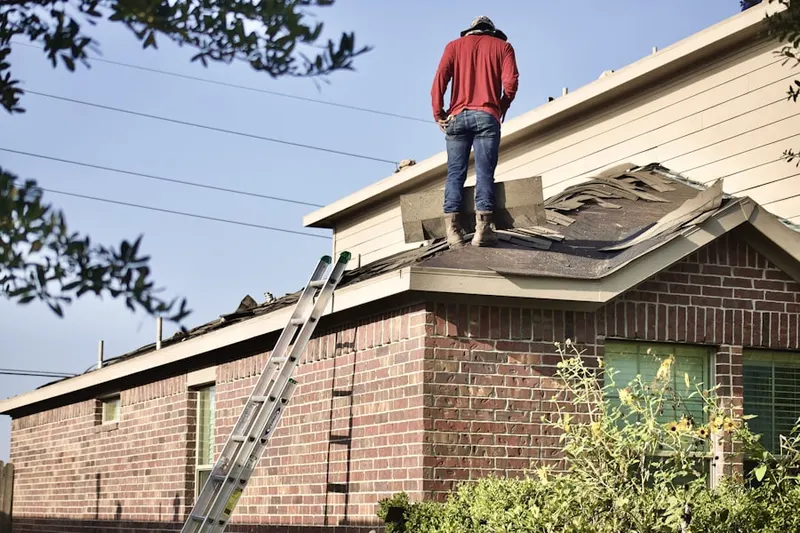 Professional roofer working on a residential roof in Collier